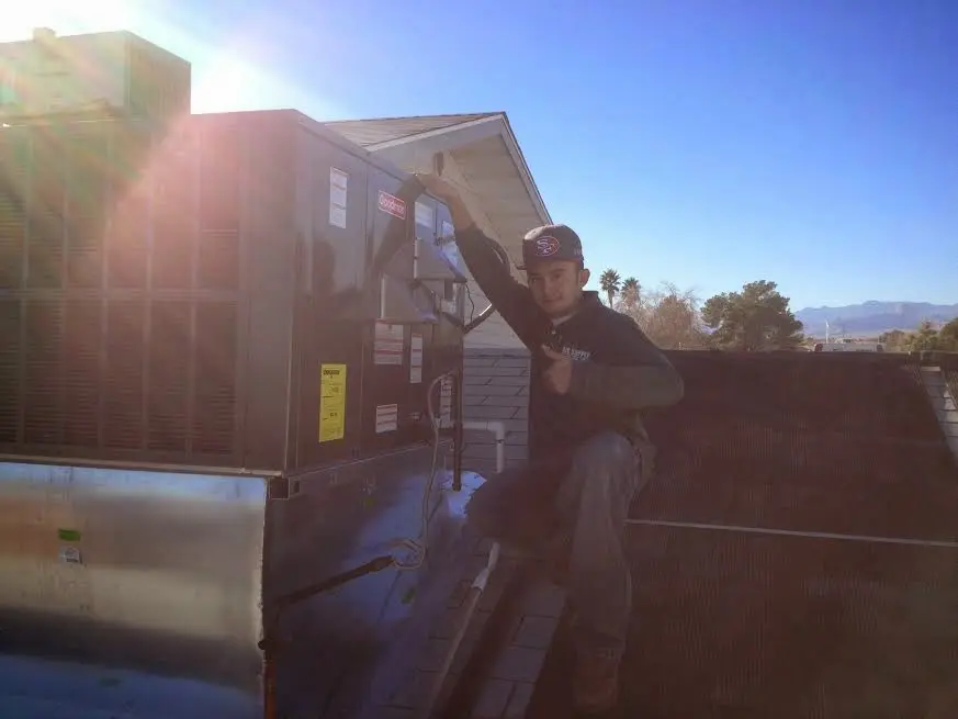 HVAC technician performing HVAC Inspection on a rooftop unit in Belvidere